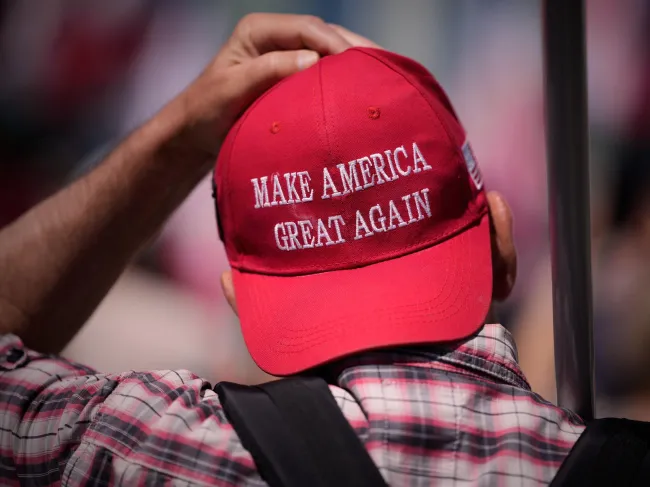 A man in a backwards red MAGA hat